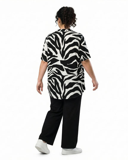 Πίσω όψη γυναίκας που φοράει ασύμμετρη ασπρόμαυρη καλοκαιρινή τουνίκ σε μεγάλα μεγέθη με αφηρημένο πριντ και μακρύτερο πίσω μέρος.