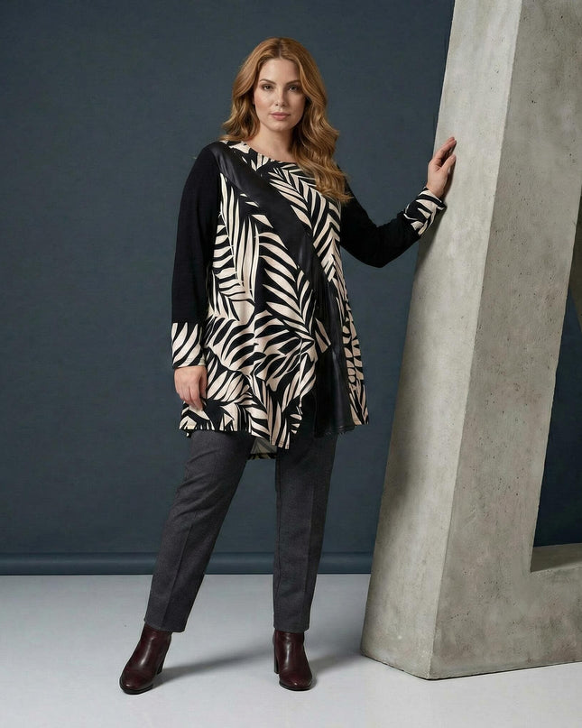 Επίσημη ασύμμετρη τουνίκ με δερματίνη και σχέδιο φύλλα σε μεγάλα μεγέθη, σε ολόσωμη φωτογραφία με το μοντέλο να ποζάρει.