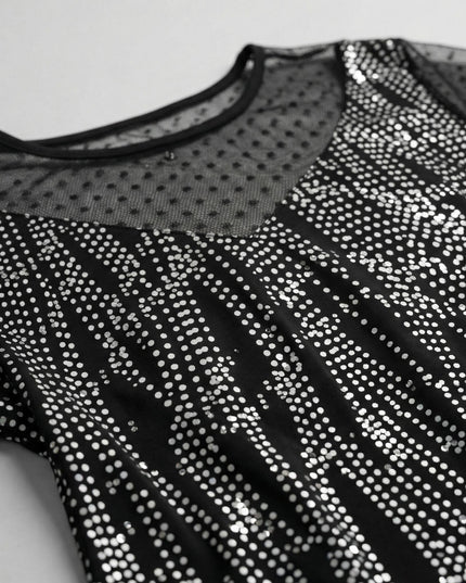 Κοντινή λήψη που εστιάζει στο ντεκολτέ επίσημης τουνίκ plus size, με μαύρο πουά τούλι στη λαιμόκοψη και ύφασμα διακοσμημένο με λαμπερή ασημοκλωστή.