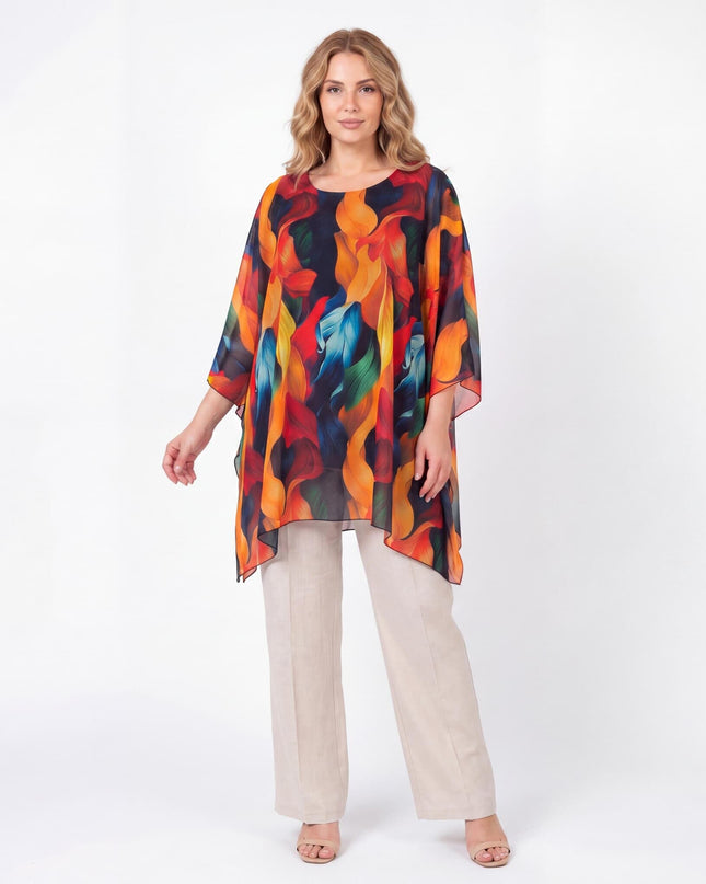 Ολόσωμη λήψη γυναίκας με επίσημη καλοκαιρινή μάξι τουνίκ πόντσο για μεγάλα μεγέθη, που αναδεικνύει το ζωηρό πολύχρωμο αφηρημένο μοτίβο της.