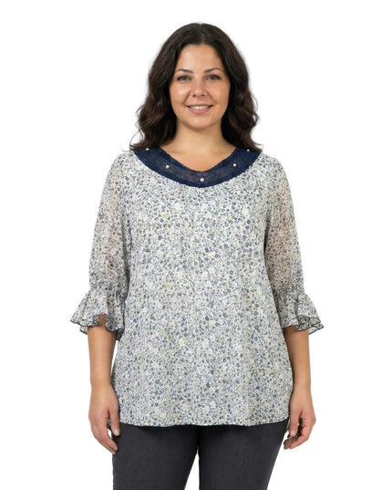 Επίσημη λευκή φλοράλ τουνίκ σε μεγάλα μεγέθη, σε μπροστινή λήψη. Διακρίνεται το ντεκολτέ με μπλε τούλι και πέρλες, καθώς και τα μανίκια με βολάν.