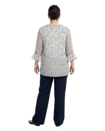 Πίσω όψη της επίσημης λευκής φλοράλ τουνίκ σε μεγάλα μεγέθη, με λεπτομέρειες βολάν στα μανίκια. Η άνετη γραμμή στην πλάτη προσφέρει κομψότητα και ελευθερία κινήσεων.