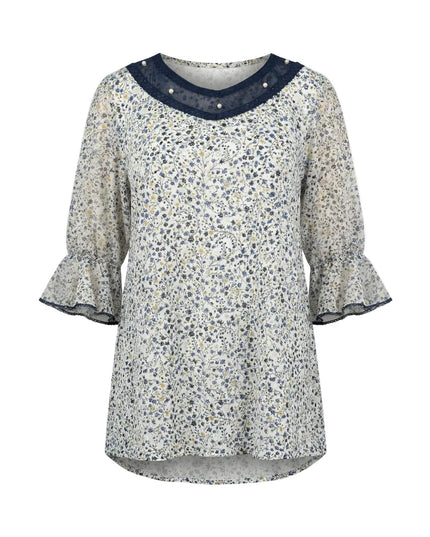 Επίσημη λευκή φλοράλ τουνίκ σε μεγάλα μεγέθη, με διακόσμηση από πέρλες και τούλι στο ντεκολτέ και μανίκια με βολάν, σε λευκό φόντο.