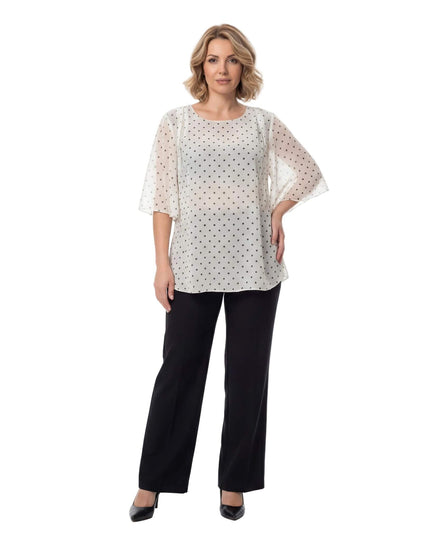 Επίσημη λευκή τουνίκ από σιφόν με μαύρο πουά και αέρινα μανίκια, σε ολόσωμη λήψη με μαύρο παντελόνι, σχεδιασμένη για μεγάλα μεγέθη.