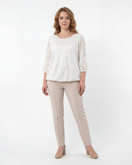 Ολόσωμη λήψη σε λευκό φόντο με επίσημη λευκή τουνίκ plus size. Ξεχωρίζει το ανάγλυφο φλοράλ σχέδιο στα διάφανα μανίκια και το λάστιχο στο τελείωμα.