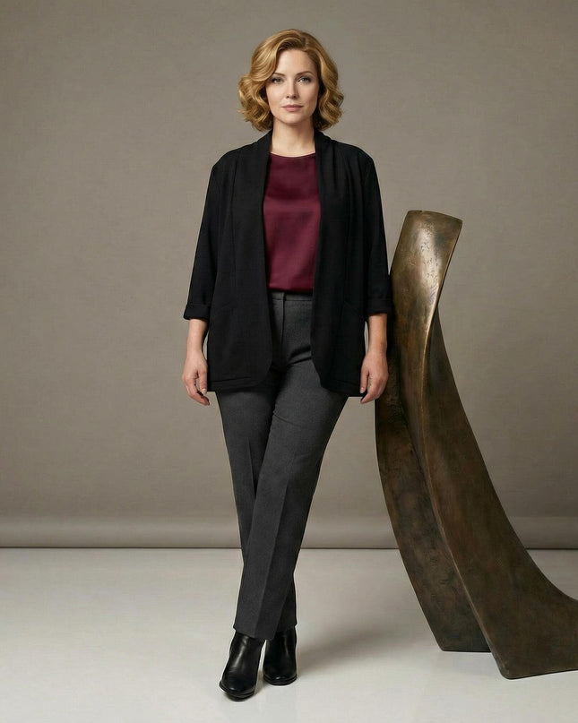 Επίσημη μαύρη γυναικεία ζακέτα βισκόζη με τσέπες σε μεγάλα μεγέθη, φορεμένη με μπορντό μπλούζα σε ολόσωμη λήψη.