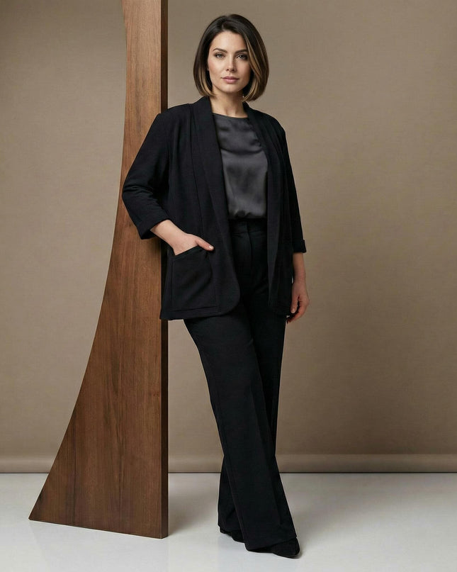 Επίσημη μαύρη γυναικεία ζακέτα από βισκόζη σε ολόσωμη λήψη. Κομψό σχέδιο χωρίς κούμπωμα με πρακτικές τσέπες, φορεμένη με σατέν μπλούζα για μεγάλα μεγέθη.