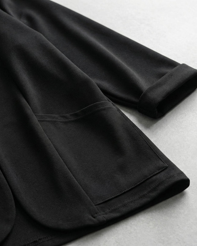 Κοντινή λήψη από επίσημη μαύρη γυναικεία ζακέτα βισκόζη σε μεγάλα μεγέθη, εστιάζοντας στην πλαϊνή τσέπη, το γύρισμα στο μανίκι και την απαλή υφή του υφάσματος.