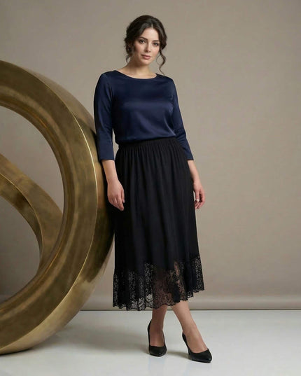 Ολόσωμη λήψη με επίσημη μαύρη μάξι φούστα σε μεγάλα μεγέθη. Το μοντέλο αναδεικνύει την εβαζέ γραμμή και την κομψή δαντέλα στο κάτω μέρος.