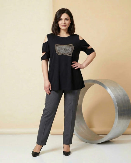 Ολόσωμη λήψη γυναίκας που φοράει την επίσημη μαύρη μάξι τουνίκ συνδυασμένη με γκρι παντελόνι.