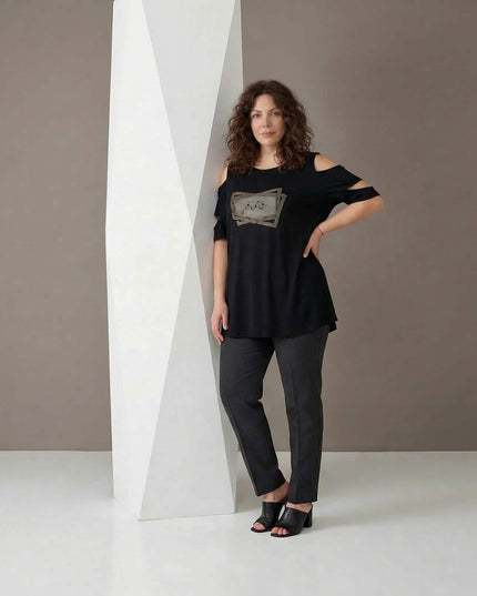 Ολόσωμη λήψη μοντέλου που φοράει επίσημη μαύρη μάξι τουνίκ plus size, με ανοιχτούς ώμους, διακόσμηση με στρας και εβαζέ γραμμή.