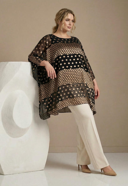 Ολόσωμη λήψη: Επίσημη μαύρη plus size τουνίκ πόντσο από διαφανές σιφόν ύφασμα με εντυπωσιακά χρυσά πουά, συνδυασμένη με ιβουάρ παντελόνι.