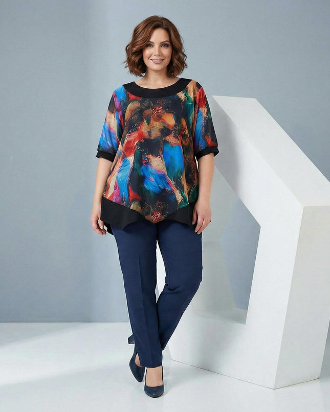 Ολόσωμη φωτογραφία γυναίκας που φοράει επίσημη μαύρη τουνίκ σε μεγάλα μεγέθη, με ασύμμετρο σιφόν και εντυπωσιακό πολύχρωμο print στο μπροστινό μέρος.