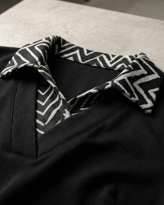 Κοντινή λεπτομέρεια του γιακά σε επίσημη μαύρη τουνίκ plus size, με εντυπωσιακό ασπρόμαυρο γεωμετρικό μοτίβο και κομψή λαιμόκοψη V.