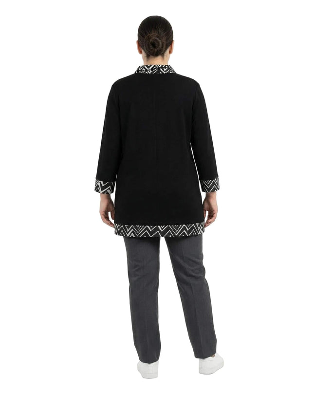 Επίσημη μαύρη τουνίκ plus size σε ολόσωμη λήψη από την πίσω πλευρά, με ασπρόμαυρο γεωμετρικό σχέδιο στο στρίφωμα και τις μανσέτες.