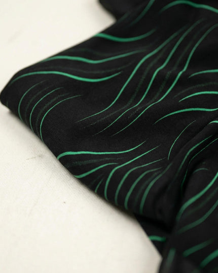 Κοντινή λεπτομέρεια υφάσματος σε επίσημη μαύρη τουνίκ μεγάλων μεγεθών με μοντέρνο κυματιστό σχέδιο.