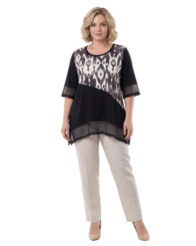 Ολόσωμη λήψη σε λευκό φόντο. Μαύρη τουνίκ μεγάλα μεγέθη με ασύμμετρη γραμμή, αφηρημένο print και λεπτομέρειες από δίχτυ.