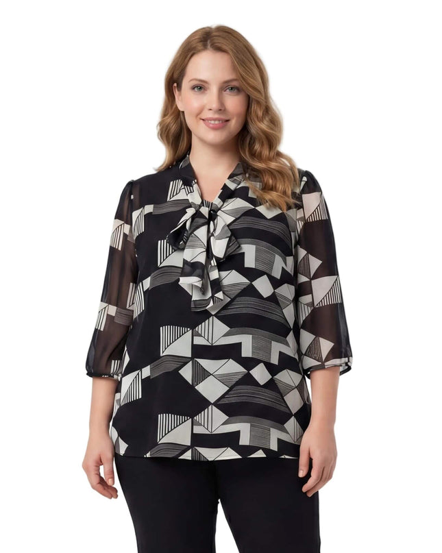 Επίσημη τουνίκ σε μεγάλα μεγέθη με γεωμετρικό μοτίβο σε μαύρο και λευκό, διακοσμητικό φιόγκο στο ντεκολτέ και αέρινα μανίκια, σε μπροστινή λήψη.