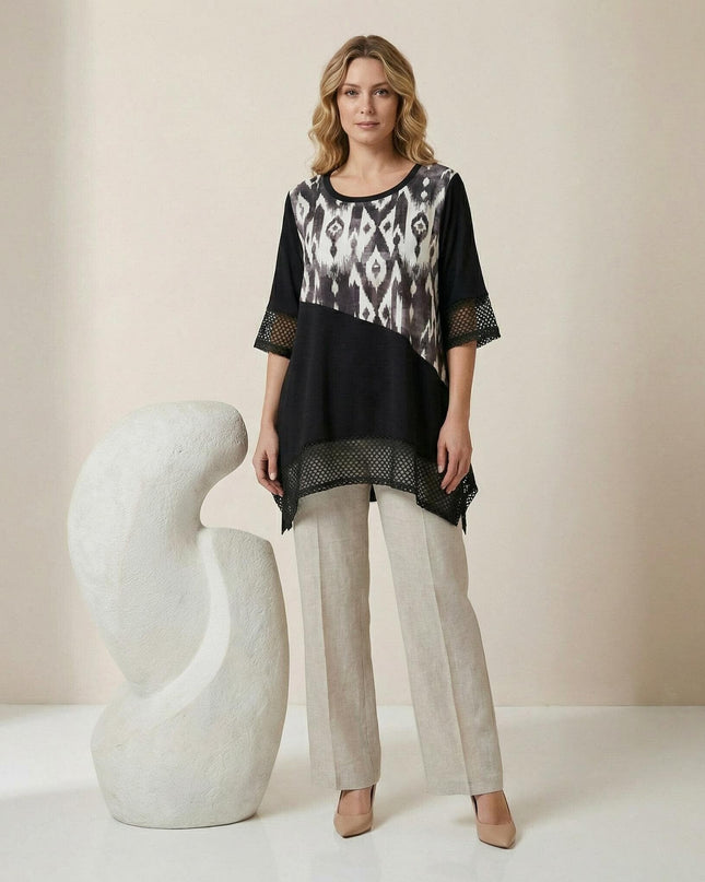 Ολόσωμη λήψη με επίσημη μαύρη τουνίκ μεγάλα μεγέθη, ασύμμετρη γραμμή, διαγώνιο ασπρόμαυρο print και λεπτομέρειες από δίχτυ.