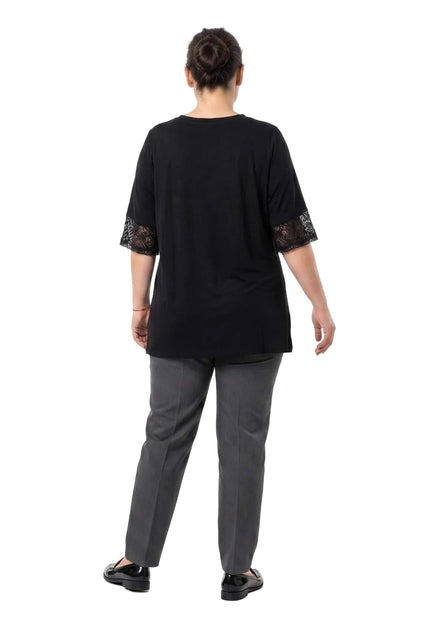 Πίσω όψη της επίσημης μαύρης τουνίκ plus size. Διακρίνεται η άνετη εβαζέ γραμμή της πλάτης και οι λεπτομέρειες με διαφανές δίχτυ στα μανίκια.