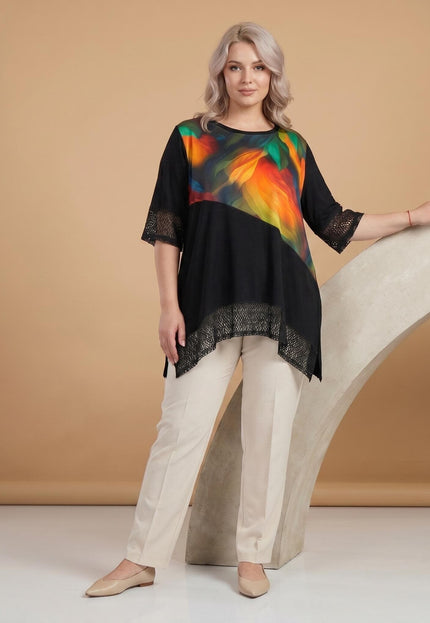 Ολόσωμη λήψη. Επίσημη μαύρη τουνίκ plus size με ασύμμετρο τελείωμα, εντυπωσιακή χρωματιστή φάσα και κομψές λεπτομέρειες από δίχτυ στα μανίκια.