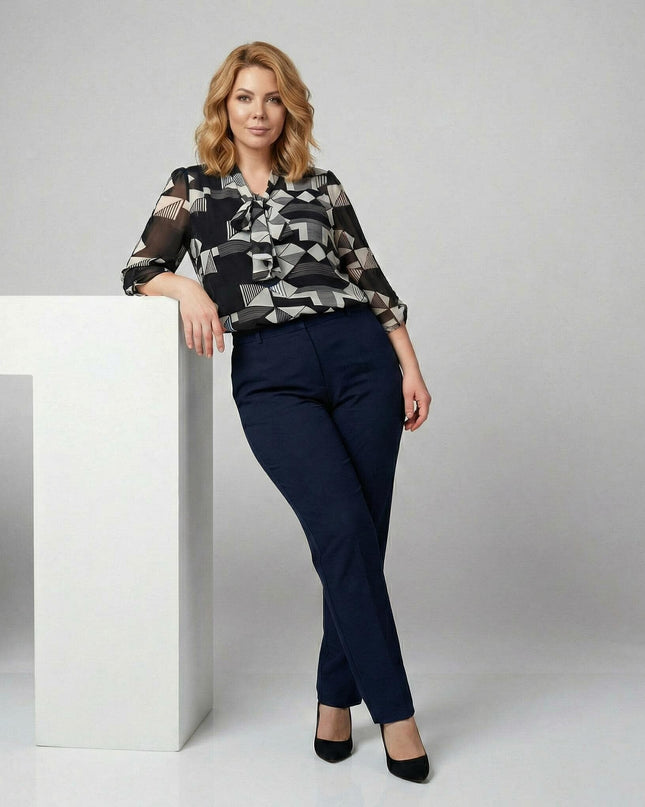 Επίσημη μαύρη τουνίκ σε μεγάλα μεγέθη με γεωμετρικό μοτίβο και φιόγκο στο λαιμό. Ολόσωμη λήψη που αναδεικνύει τα μανίκια 7/8 και την κομψή εφαρμογή του ρούχου.