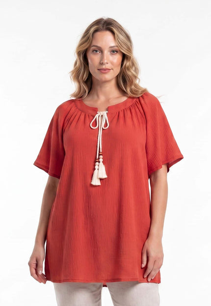 Επίσημη κεραμιδί τουνίκ σε μεγάλα μεγέθη με boho λευκά κορδόνια και φούντες στη λαιμόκοψη. Φωτογράφιση της μπροστινής όψης σε λευκό φόντο.