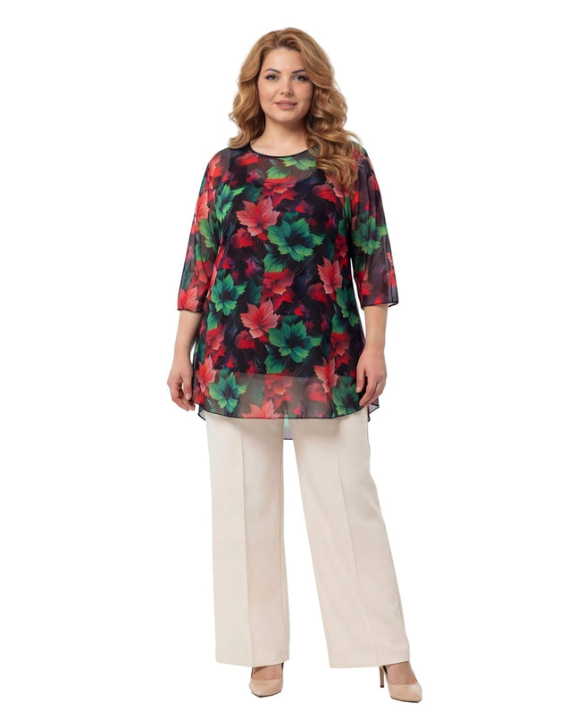 Επίσημη ριχτή τουνίκ δύο τεμαχίων plus size από αέρινο σιφόν με πολύχρωμα μοτίβα φύλλων, σε ολόσωμη λήψη με μπεζ παντελόνι.