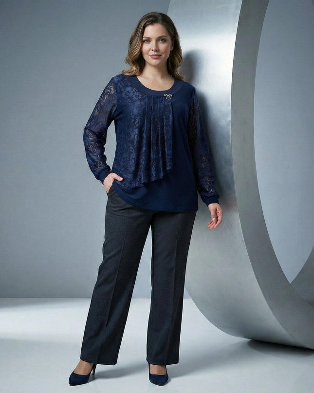 Επίσημη σκούρα μπλε τουνίκ με δαντέλα και καρφίτσα σε ολόσωμη λήψη. Κομψή plus size μπλούζα με δαντελένια μανίκια και ασύμμετρο σχέδιο για επίσημες εμφανίσεις.