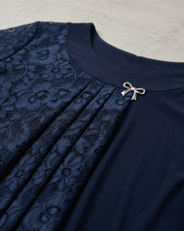 Κοντινή λεπτομέρεια από επίσημη σκούρα μπλε τουνίκ plus size, που αναδεικνύει την ανάγλυφη δαντέλα και τη διακοσμητική ασημένια καρφίτσα στο ντεκολτέ.