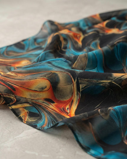 Κοντινή λεπτομέρεια υφάσματος από επίσημη τουνίκ σιφόν για μεγάλα μεγέθη, που αναδεικνύει το αφηρημένο σχέδιο με τυρκουάζ και πορτοκαλί νερά σε μαύρη βάση.