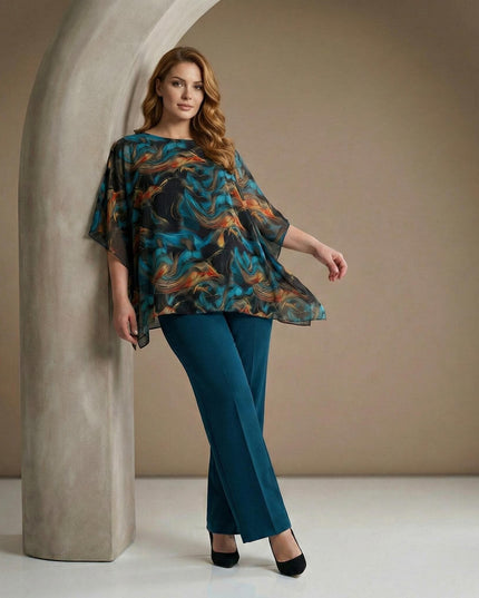 Επίσημη τουνίκ από σιφόν σε μεγάλα μεγέθη με αφηρημένο σχέδιο σε τυρκουάζ και πορτοκαλί, σε ολόσωμη λήψη μοντέλου που αναδεικνύει τα μανίκια πεταλούδα.