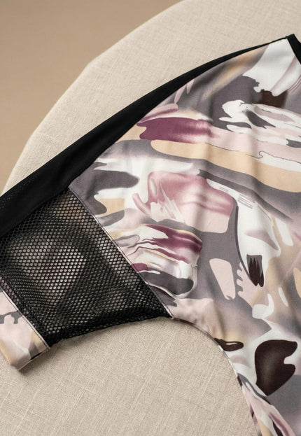 Κοντινή λεπτομέρεια σε flat lay επίσημης plus size τουνίκ. Εστιάζει στο μανίκι με ένθετο μαύρο δίχτυ και στο πολύχρωμο αφηρημένο μοτίβο.