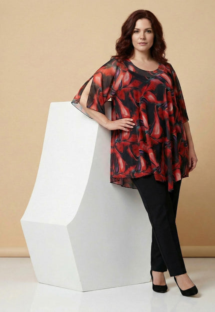 Επίσημη plus size τουνίκ από πολύχρωμο σιφόν με κόκκινες αποχρώσεις σε ολόσωμη λήψη. Έχει ασύμμετρο κόψιμο και ανοίγματα στα μανίκια για άνεση και στυλ.