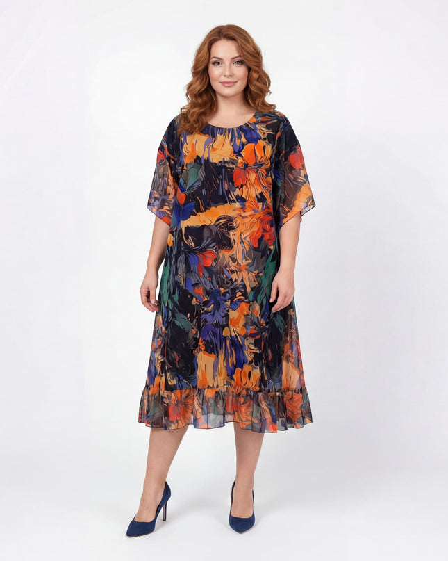 Επίσημο αέρινο εβαζέ φόρεμα σιφόν για μεγάλα μεγέθη με χρωματιστό σχέδιο σε μπλε και πορτοκαλί τόνους, σε ολόσωμη λήψη με λευκό φόντο.