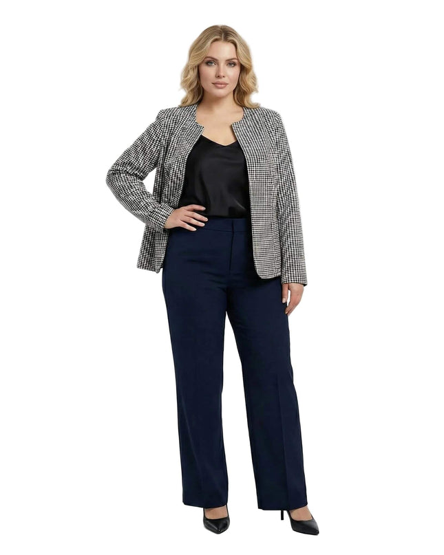 Επίσημο ελαστικό σακάκι πιέ ντε πουλ χωρίς κούμπωμα για μεγάλα μεγέθη, σε ολόσωμη λήψη φορεμένο με μαύρο τοπ και σκούρο μπλε παντελόνι.