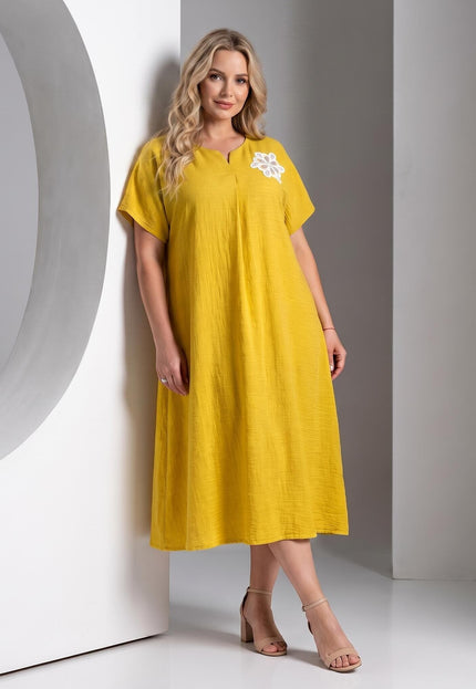 Ολόσωμη λήψη, κίτρινο επίσημο εβαζέ φόρεμα plus size. Αναδεικνύει την κομψή V λαιμόκοψη και τη λευκή φλοράλ απλικέ λεπτομέρεια.