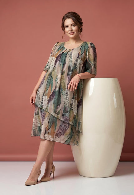 Ολόσωμη λήψη γυναίκας με επίσημο εβαζέ φόρεμα για καμπύλες, αέρινο ασύμμετρο σιφόν και μοτίβο με φύλλα.