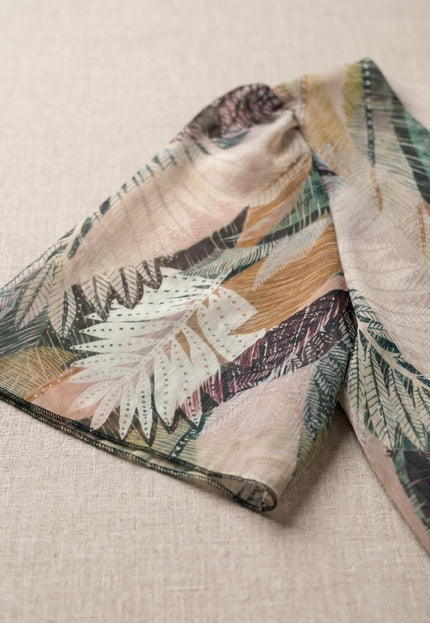 Κοντινή λεπτομέρεια στο μανίκι από επίσημο μάξι φόρεμα σε μεγάλα μεγέθη. Διακρίνεται το ημιδιάφανο σιφόν ύφασμα με πολύχρωμο σχέδιο φύλλων.