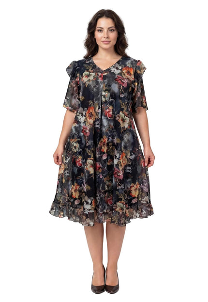 Επίσημο φλοράλ φόρεμα σιφόν σε μεγάλα μεγέθη, με μαύρη βάση, πολύχρωμα λουλούδια και βολάν στα μανίκια, σε ολόσωμη λήψη.