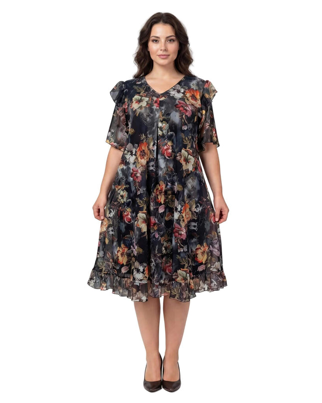 Επίσημο φλοράλ φόρεμα σιφόν σε μεγάλα μεγέθη, με μαύρη βάση, πολύχρωμα λουλούδια και βολάν στα μανίκια, σε ολόσωμη λήψη.