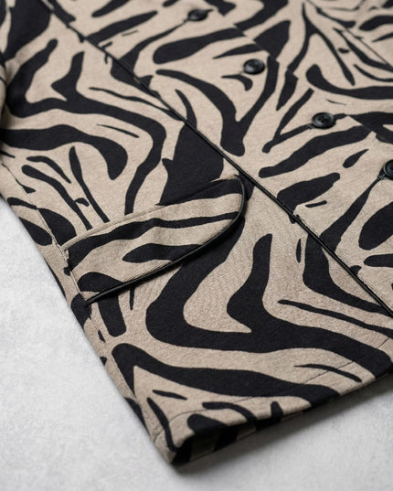 Κοντινή λεπτομέρεια από επίσημο γυναικείο σακάκι μπεζ σε μεγάλα μεγέθη, εστιάζοντας στο ιδιαίτερο μοτίβο με μαύρες ραβδώσεις και τη διακοσμητική τσέπη.