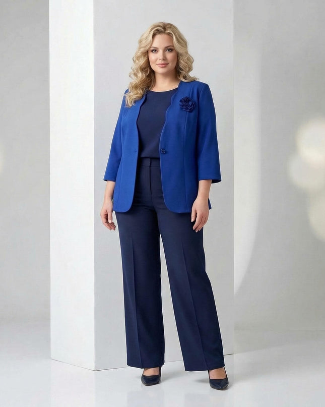 Ολόσωμη λήψη με επίσημο γυναικείο σακάκι μεγάλα μεγέθη μπλε ρουά με τριαντάφυλλο, ανοιχτό πάνω από ασορτί τοπ και παντελόνι.