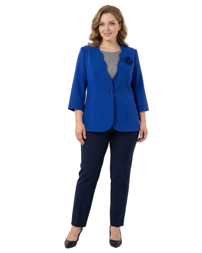 Ολόσωμη λήψη μπροστά σε λευκό φόντο: Επίσημο γυναικείο σακάκι μεγάλα μεγέθη σε μπλε ρουά, με κυματιστό γιακά και τριαντάφυλλο.