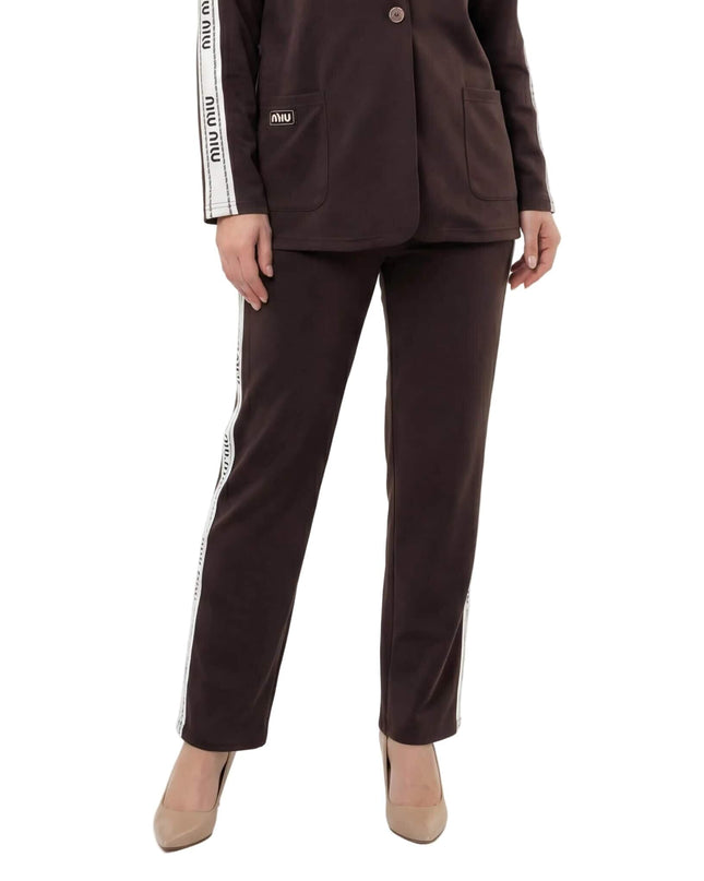 Επίσημο γυναικείο σετ δύο τεμαχίων σε καφέ χρώμα plus size, κοντινή λήψη που εστιάζει στο παντελόνι με τη λευκή πλάγια ρίγα και το κάτω μέρος του σακακιού.