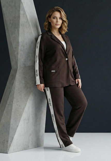 Επίσημο γυναικείο σετ plus size σε καφέ χρώμα, που περιλαμβάνει σακάκι και παντελόνι με λευκή ρίγα στο πλάι, σε ολόσωμη λήψη.