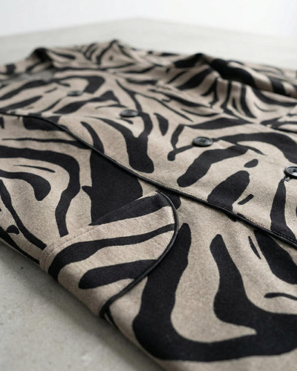 Κοντινή λεπτομέρεια υφάσματος και σχεδίου σε επίσημο γυναικείο σακάκι μπεζ μεγάλα μεγέθη, με μαύρες λεπτομέρειες και κουμπιά.