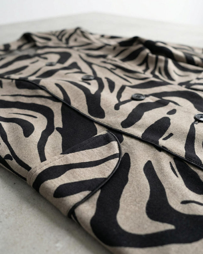 Κοντινή λεπτομέρεια υφάσματος και σχεδίου σε επίσημο γυναικείο σακάκι μπεζ μεγάλα μεγέθη, με μαύρες λεπτομέρειες και κουμπιά.