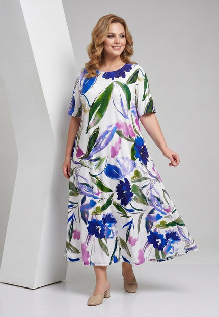 Λευκό καλοκαιρινό φλοράλ μάξι φόρεμα plus size με μπλε, πράσινα και μωβ λουλούδια και κοντά μανίκια, σε ολόσωμη λήψη.