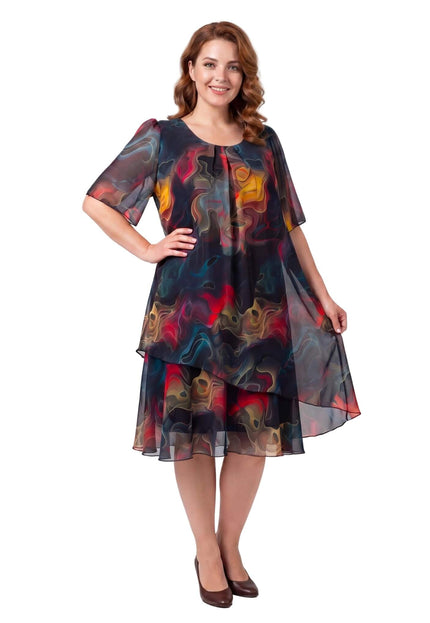 Ολόσωμη λήψη σε λευκό φόντο. Γυναικείο επίσημο καλοκαιρινό φόρεμα plus size από σιφόν με πολύχρωμο αφηρημένο μοτίβο και ασύμμετρο τελείωμα.